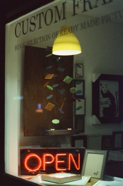 Custom framing shop neon sign at night, film