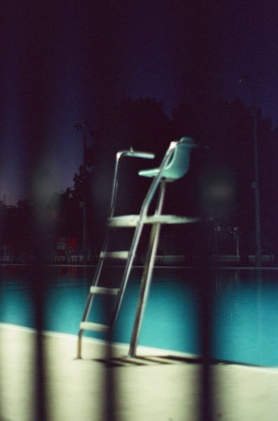 Lifeguard chair at pool at night, film
