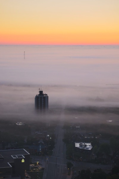 City in fog at sunrise, digital